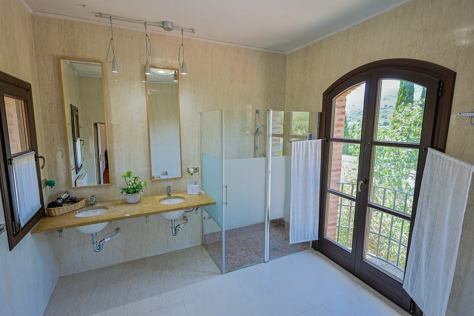Baño de La Torre con dos lavabos, ducha y puerta en arco
