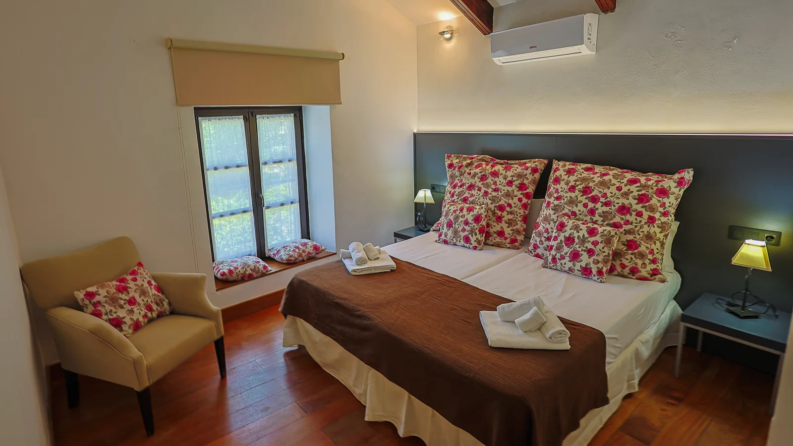 Dormitorio de La Torre con cojines florales y ventana
